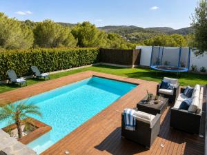 a backyard with a swimming pool and a patio with chairs at VILLA PARADISE SILVIA in Sant Pere de Ribes