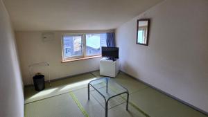 an empty room with a chair and a television at Shimano Yado Rishirikuru in Rishiri