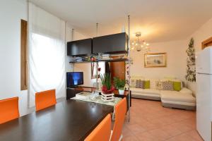 a kitchen and living room with a table and chairs at Peperoncino Home in Pedeguarda