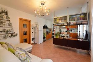 a living room with a couch and a kitchen at Peperoncino Home in Pedeguarda