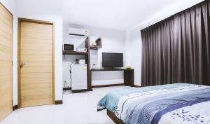 1 dormitorio con 1 cama y TV en Ra Residence Phuket en Chalong 
