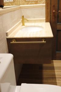 a bathroom with a sink with a gold faucet at Posada San Miguel Arcángel Experience in Arévalo +66 photos