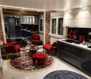 a living room with red chairs and a kitchen at Eleni De Lux - Indoor Jacuzzi Residence in Lydia in Lidia