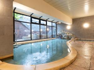 a large swimming pool with a large window at Itoen Hotel Hakone Yumoto in Hakone