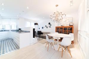 a white kitchen and dining room with a table and chairs at Apartamento Platas Centro in Ribadesella