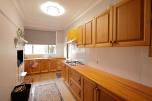 a kitchen with wooden cabinets and a counter top at Cosy Sun-Filled Cottage in Tenterfield +21 photos