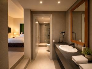 a bathroom with a sink and a toilet and a bed at Monopatia Resort in Ano Pedina +69 photos