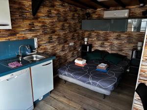 a small room with a bed and a sink at Logement avec clim - thé, café et choco dispo in Oye-Plage