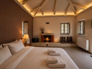 a bedroom with a bed with two towels on it at Monopatia Resort in Ano Pedina
