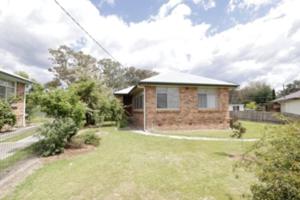 a brick house with a yard at Cosy Sun-Filled Cottage in Tenterfield