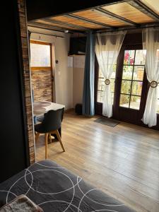 a room with a bed and a table and windows at Logement avec clim - thé, café et choco dispo in Oye-Plage