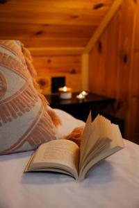 an open book sitting on a bed with a pillow at Zen Sasino in Sasino