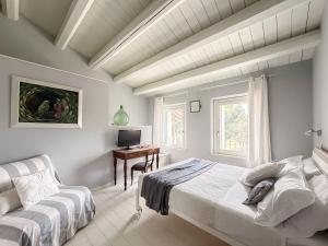 a bedroom with a bed and a desk with a computer at Borgoparvo Countryvilla in Sirolo