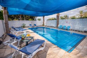 a swimming pool with chairs and a table next to it at Pine Tree Cabin in Moshav Ramot