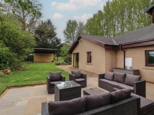 a patio with a couch and chairs and a table at Old Riggs Paddock in Penrith