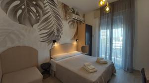 a bedroom with a bed with two towels on it at B&B Hotel Serenità in Bellaria-Igea Marina
