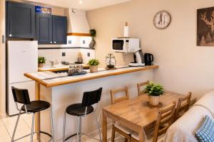 a kitchen and dining room with a table and chairs at Grand Studio Tout Confort pour 3 personnes Linge en option in Barcelonnette +30 photos