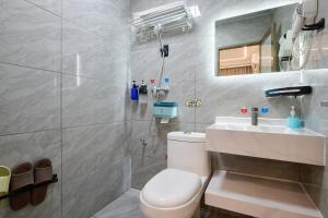 a bathroom with a toilet and a sink at Four Seasons Clouds Xiamen North Railway Station Store in Xiamen