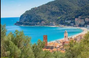 a view of a town with a beach and the ocean at La Testa Fra Le Nuvole in Finale Ligure +21 photos