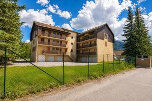 a building with a fence in front of it at Grand Studio Tout Confort pour 3 personnes Linge en option in Barcelonnette