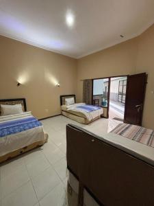 a bedroom with two beds and a balcony at Hotel Prima Asri 153 in Batu