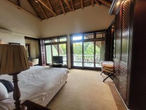 a bedroom with a bed and a desk and window at Ridgemor Villa in Somerset West +24 photos