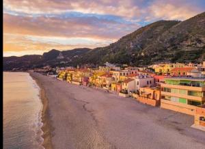 a view of a beach with buildings and the water at La Testa Fra Le Nuvole in Finale Ligure