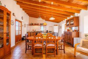 a kitchen and dining room with a wooden table and chairs at Ca Sa Padrina Banyalbufar in Banyalbufar