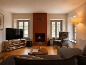 a living room with a couch and a fireplace at Monopatia Resort in Ano Pedina