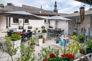 an outdoor patio with tables and chairs and umbrellas at Über den Dächern in Cochem Altstadt in Cochem