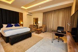 a bedroom with a bed and a desk and a computer at Vintano Hotel in Lagos +16 photos