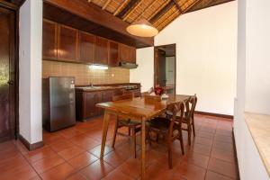 a kitchen with a wooden table and chairs at The Buyan Resort Bedugul in Bedugul