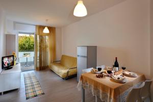 a kitchen and living room with a table and a couch at Hotel Luciana in Bibione