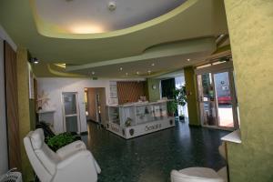 a living room with white chairs and a counter in a room at Hotel Senator in Slatina