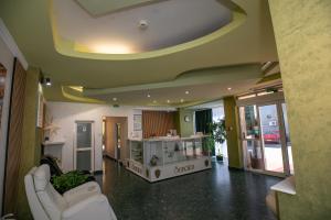 a living room with two white couches in a room at Hotel Senator in Slatina