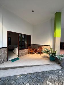 a patio with two chairs and a table in a building at Hotel Prima Asri 153 in Batu