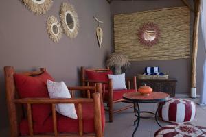 a living room with red chairs and a table at Kasbah Beldy Chic Marrakech, heated pool, spa in Marrakesh
