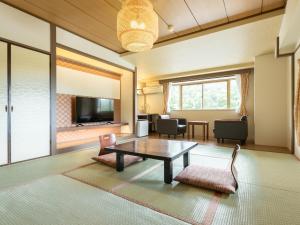 a living room with a coffee table and a dining room at Itoen Hotel Hakone Yumoto in Hakone