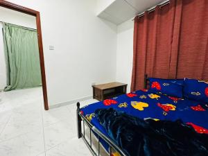 a bedroom with a bed with a blue comforter at 16 Villa in Sabkhah