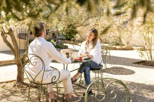 a man and a woman sitting at a table at Hôtel La Garrigue & Bar Le Perchoir in Venasque