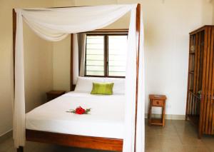 een slaapkamer met een hemelbed met een bloem erop bij Santo Seaside Villas in Luganville