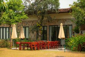 a group of tables and chairs with umbrellas at Villa Valley De Mango Hue in Thôn Châu Chữ