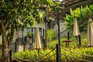 a group of umbrellas and tables in a garden at Villa Valley De Mango Hue in Thôn Châu Chữ +111 photos