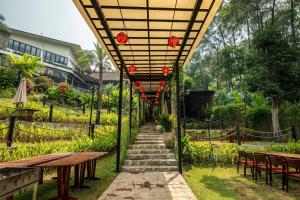 a patio with tables and chairs and red flowers at Villa Valley De Mango Hue in Thôn Châu Chữ