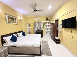 a bedroom with a bed and a flat screen tv at Staylo Suites Edit in New Delhi