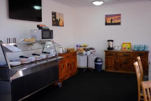 a kitchen with a counter with a microwave at Cobar Central Motor Inn in Cobar