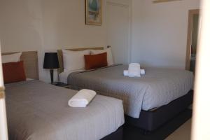 two beds sitting next to each other in a bedroom at Cobar Central Motor Inn in Cobar +17 photos