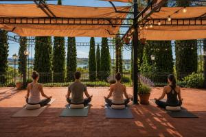 a group of people sitting in a yoga pose at Terracqua Retreat I Essence of Tuscany in Chiusi