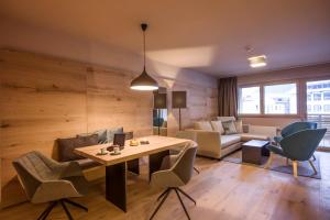 een woonkamer met een tafel en stoelen en een bank bij Postresidenz in Mayrhofen