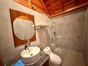 a bathroom with a sink and a toilet and a mirror at Prasi Sunrise Sea View in Nusa Penida +78 photos
